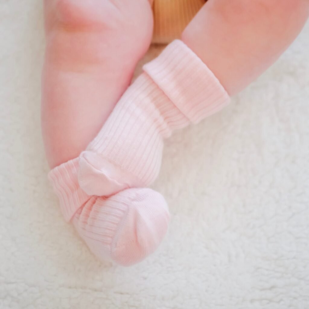 Baby feet dressed in cozy pink wool socks