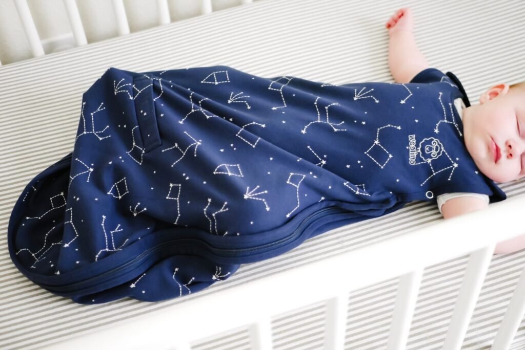 Baby sleeping safely on their back in a crib wearing a merino wool sleep sack