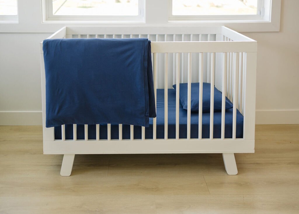 Navy blue organic cotton crib bedding in a nursery