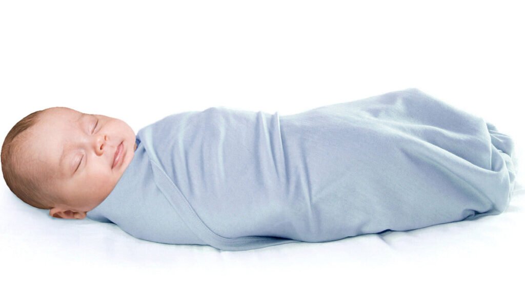 Sleeping infant wrapped in a merino wool swaddle blanket